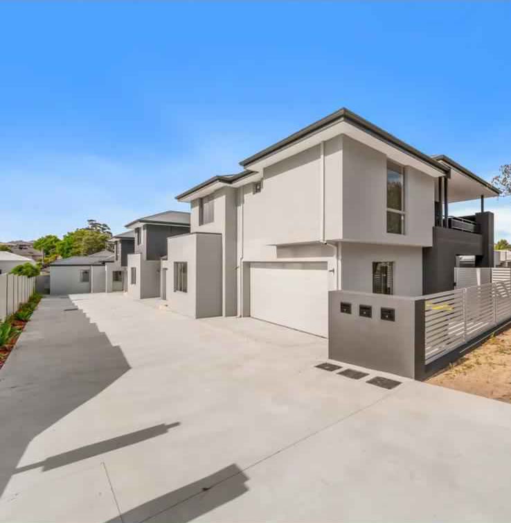 Row of new two-storey townhouses along a shared driveway