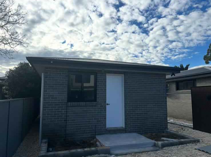 Completed dark brick granny flat in a backyard