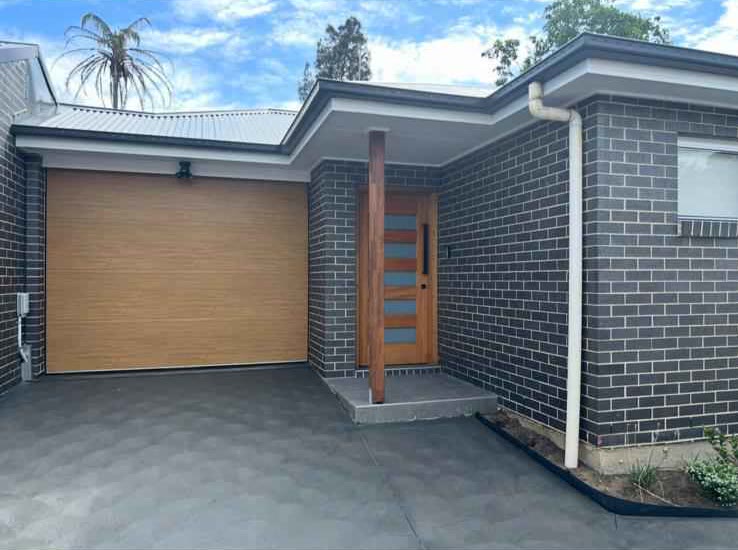Completed brick dwelling with a timber-look garage door